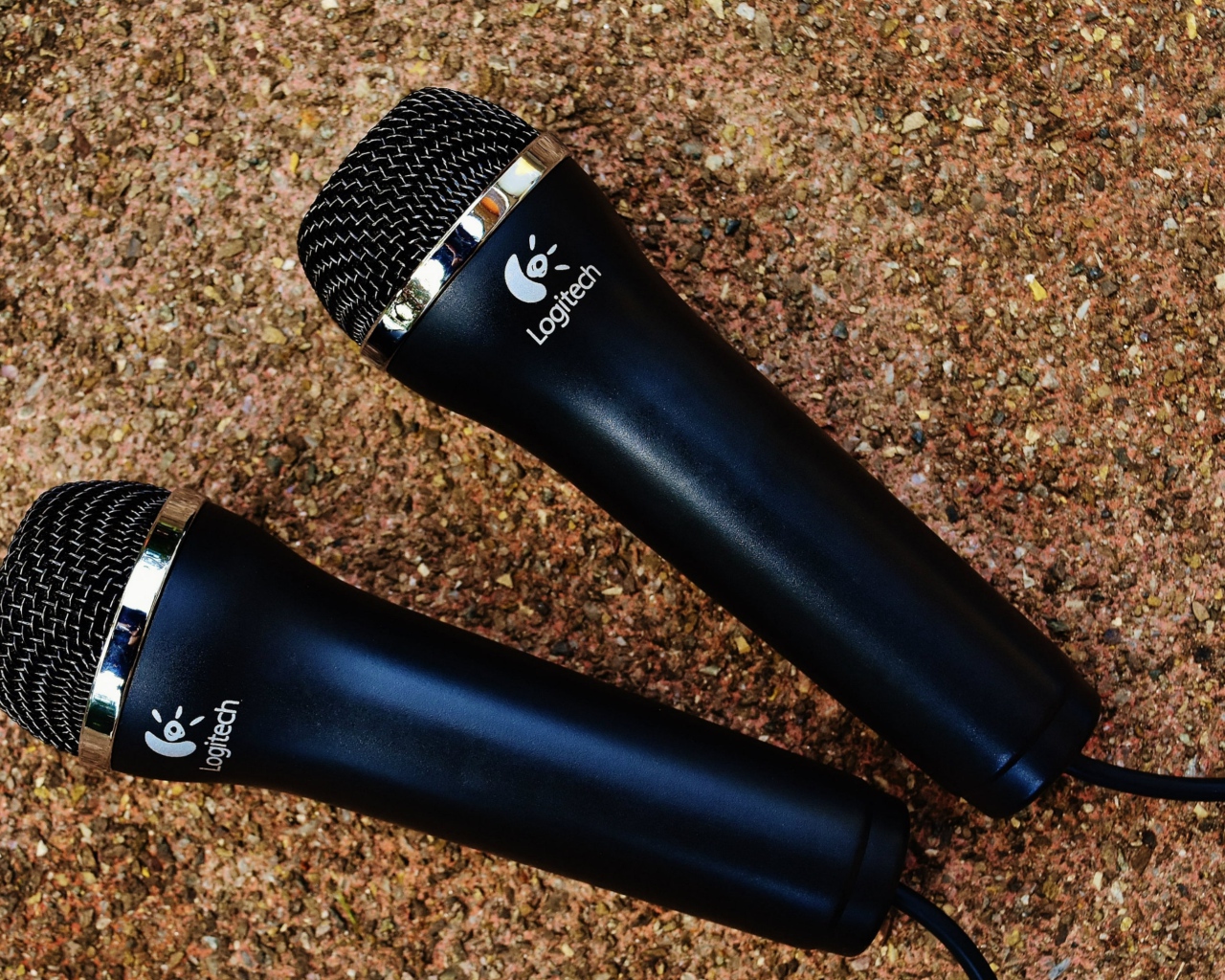 Two Logitech microphones on the pavement