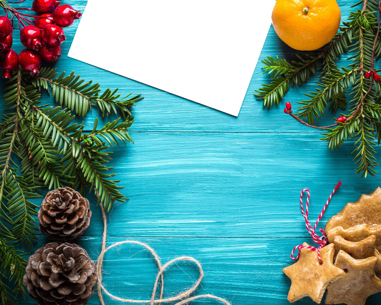 Еловые ветки с печеньем, шишками и декором на синем фоне