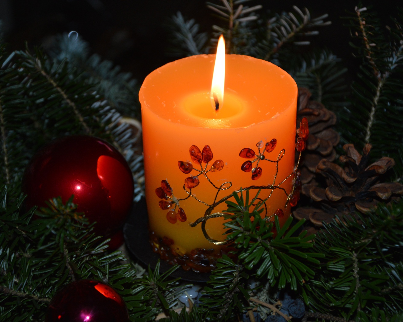 Зажженная свеча с ветками ели 