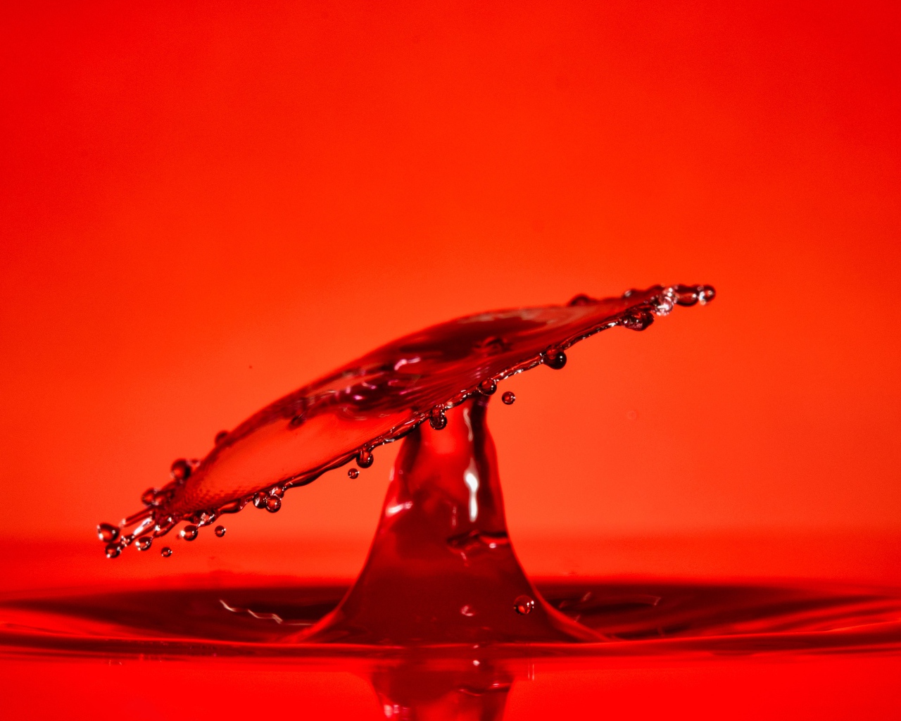Брызги воды на красном фоне