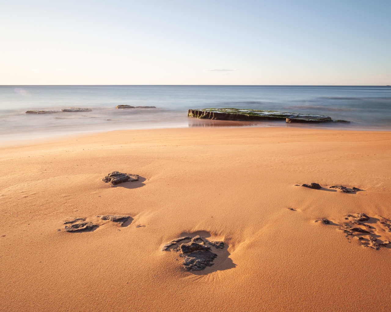 Камни в песке на берегу моря 