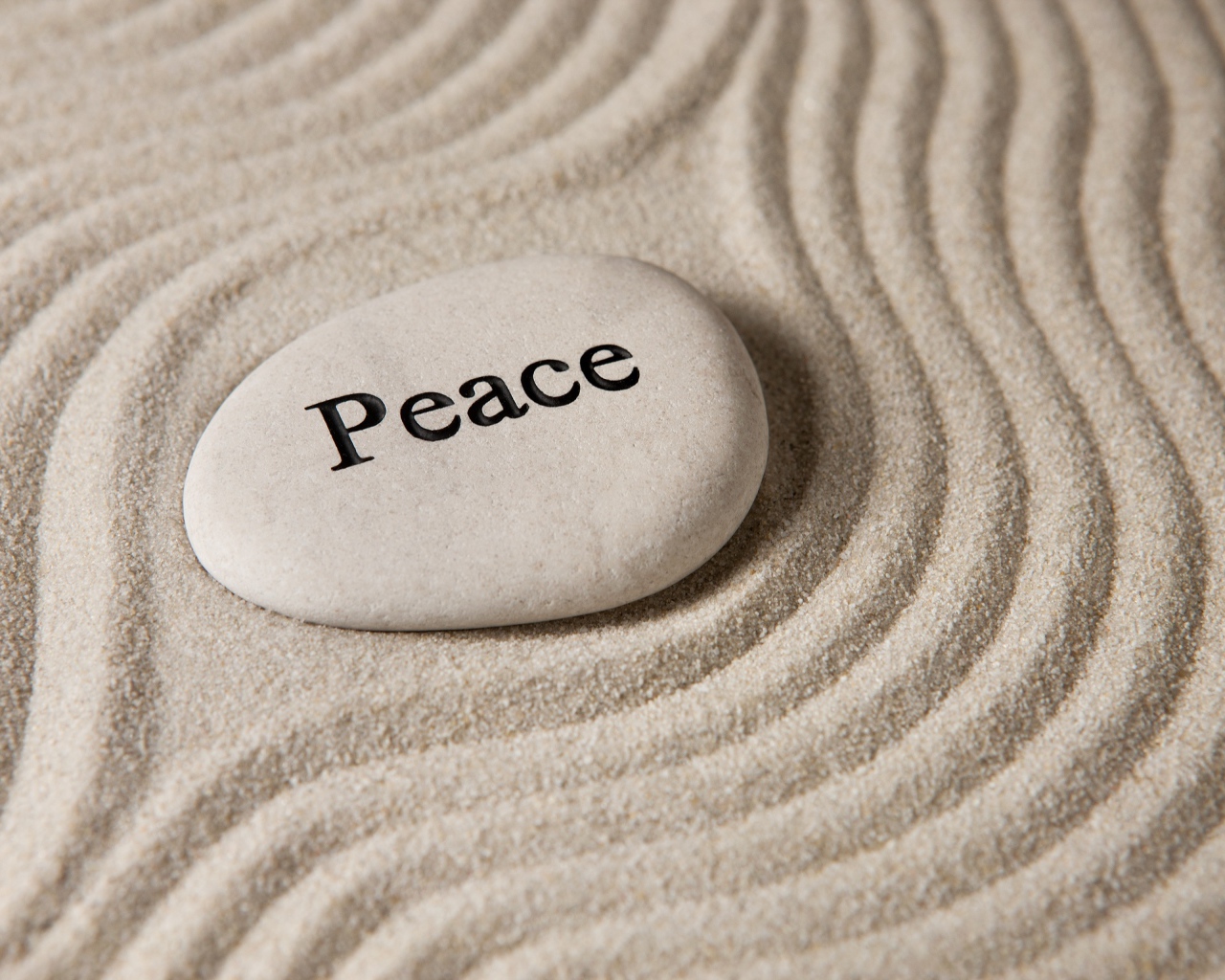 Белый камень с надписью на песке с волнами