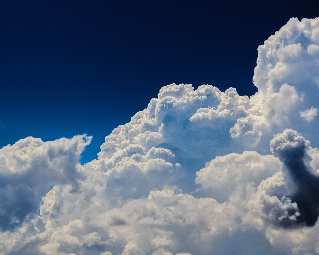 Густые белые облака в голубом небе в лучах солнца