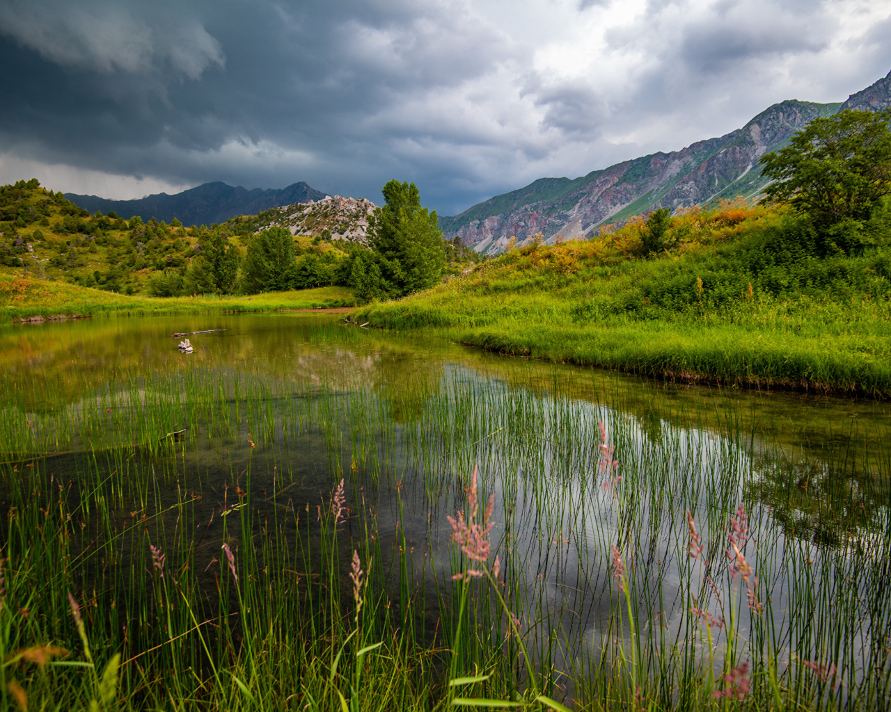Грозовые облака над рекой в горах 