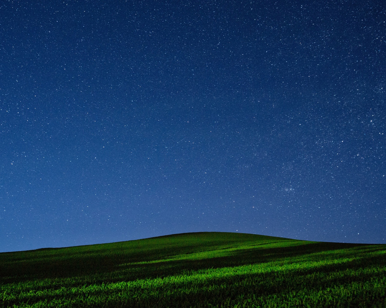 Красивое звездное ночное небо над зеленым полем