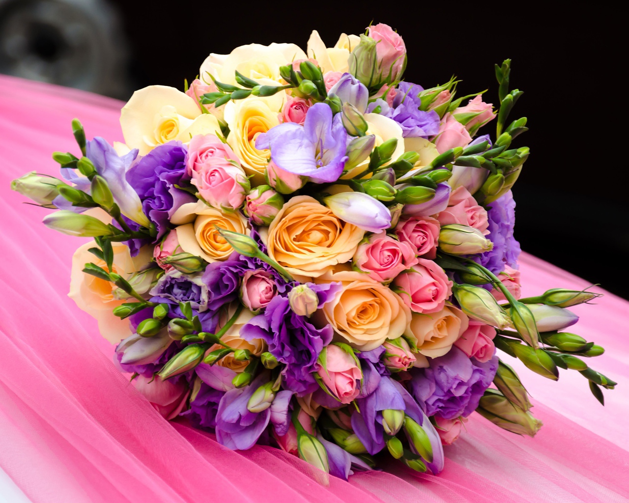 Красивый свадебный букет лежит на розовой ткани