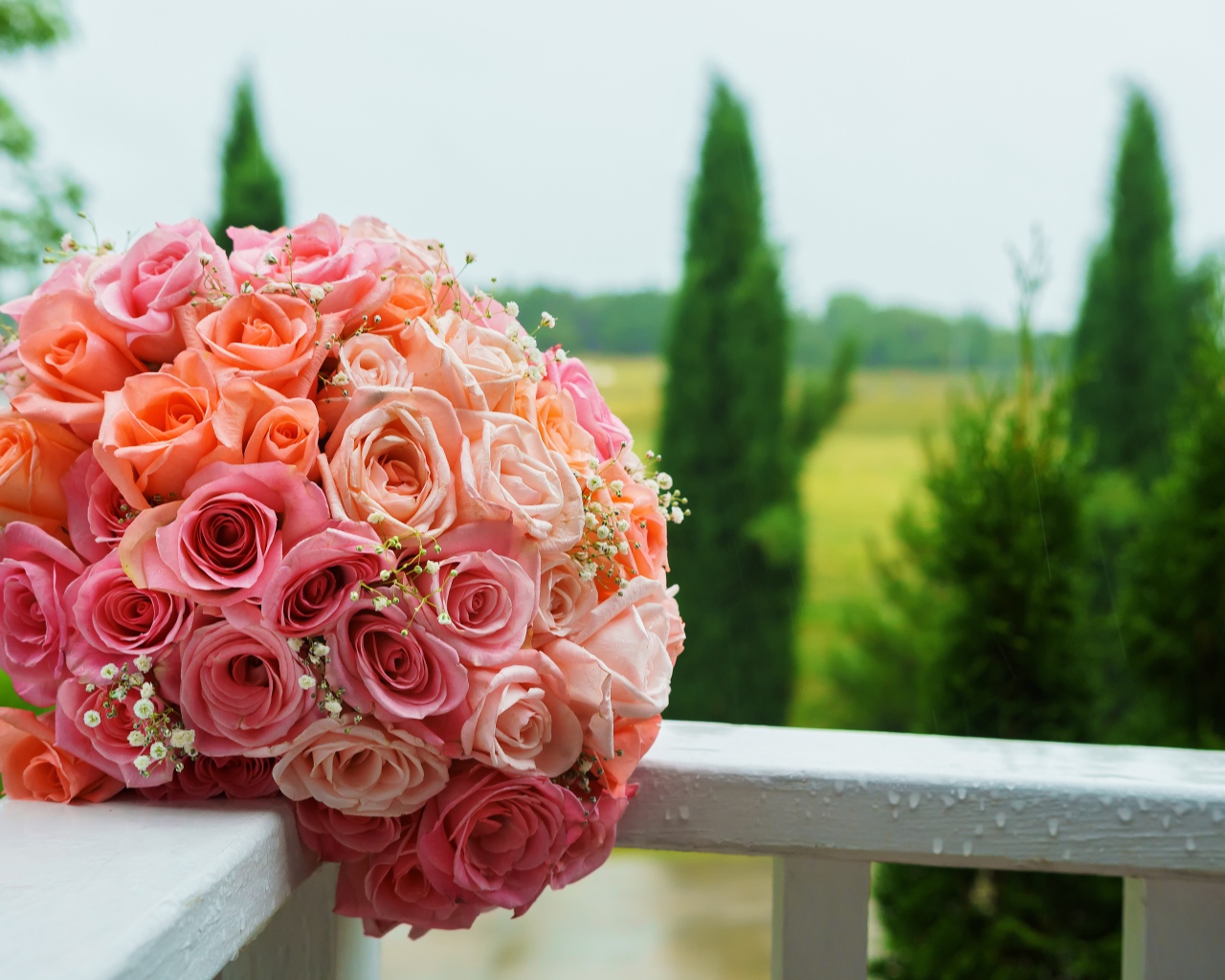 Красивый свадебный букет розовых роз на белых перилах