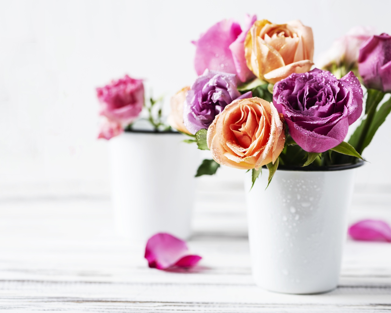 Букет разноцветных роз в белой вазе на столе