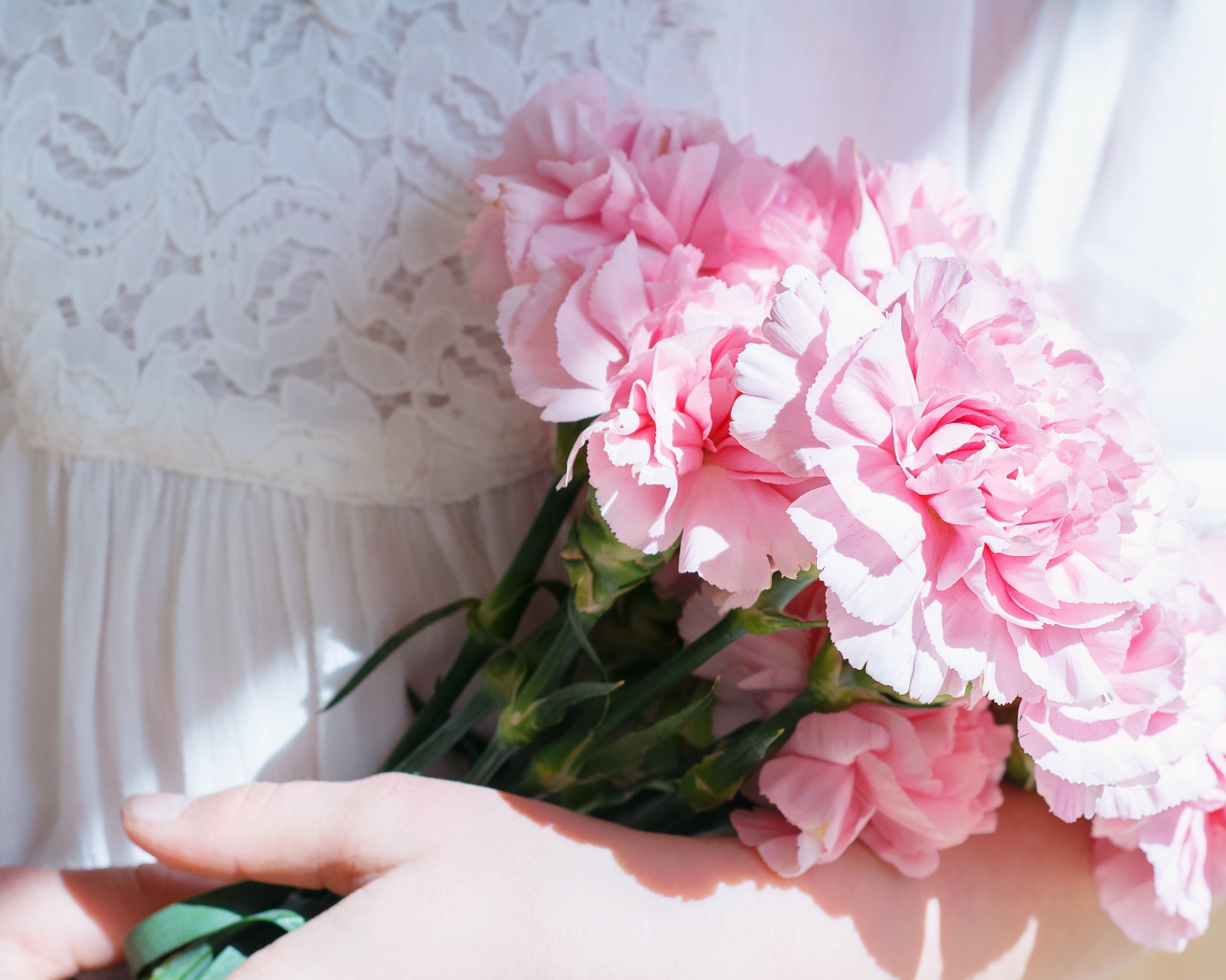 Букет розовых цветов гвоздики в руках у невесты