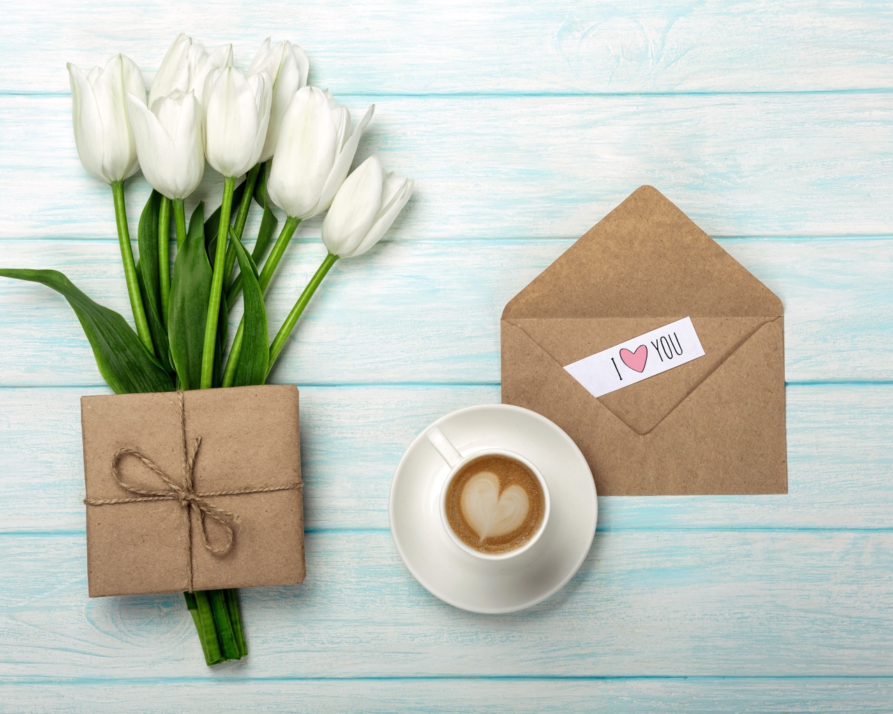 Bouquet of white tulips on a table with a gift and a cup of coffee