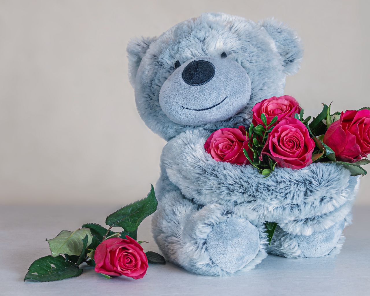 Серый медвежонок с букетом роз