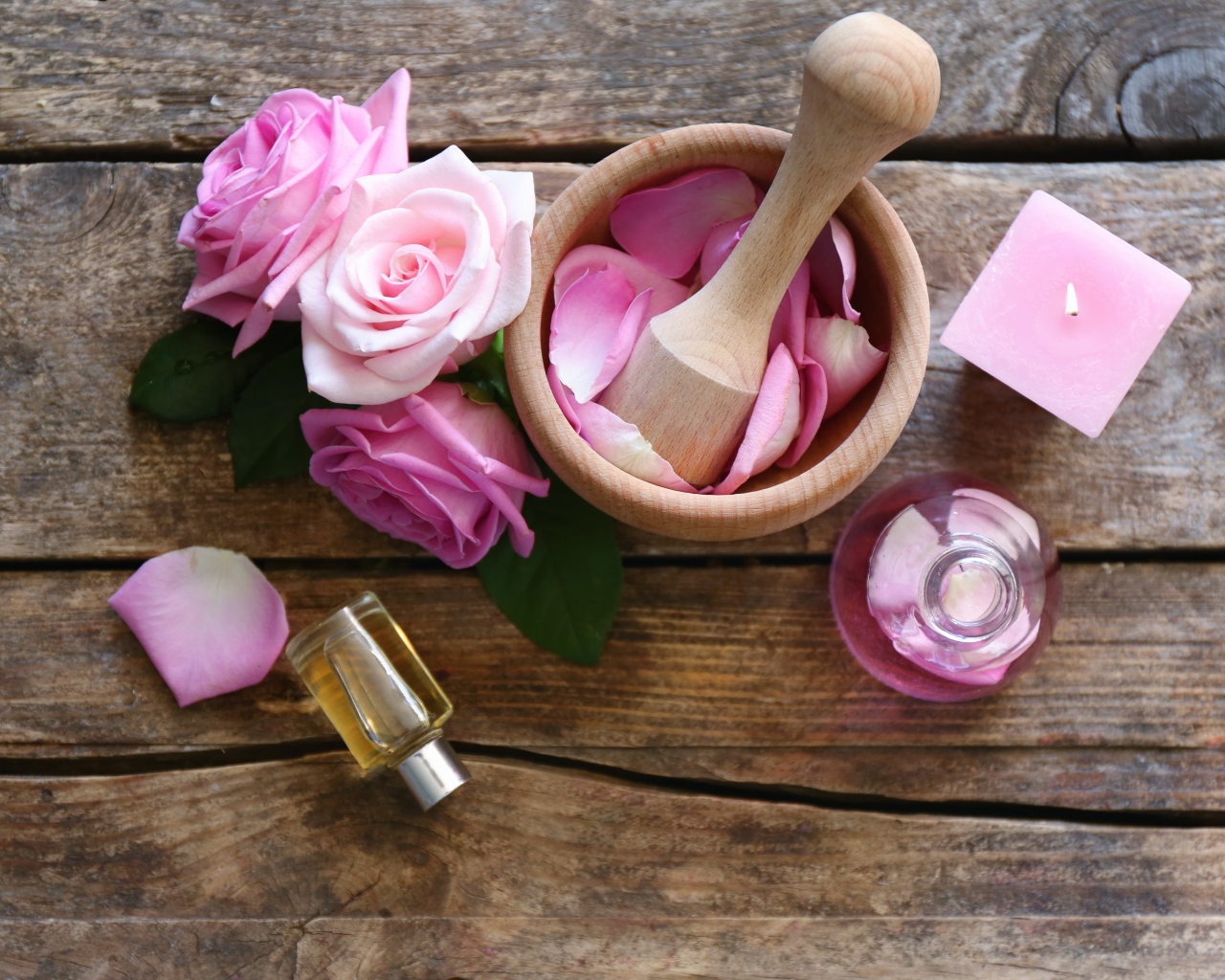 Лепестки розовой розы в ступке на столе с маслом