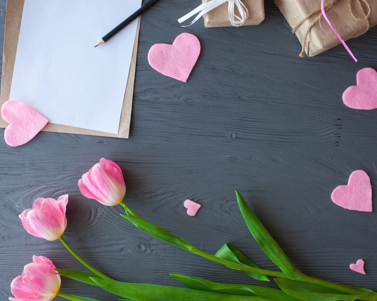 Тюльпаны, лист бумаги и сердечки на сером столе