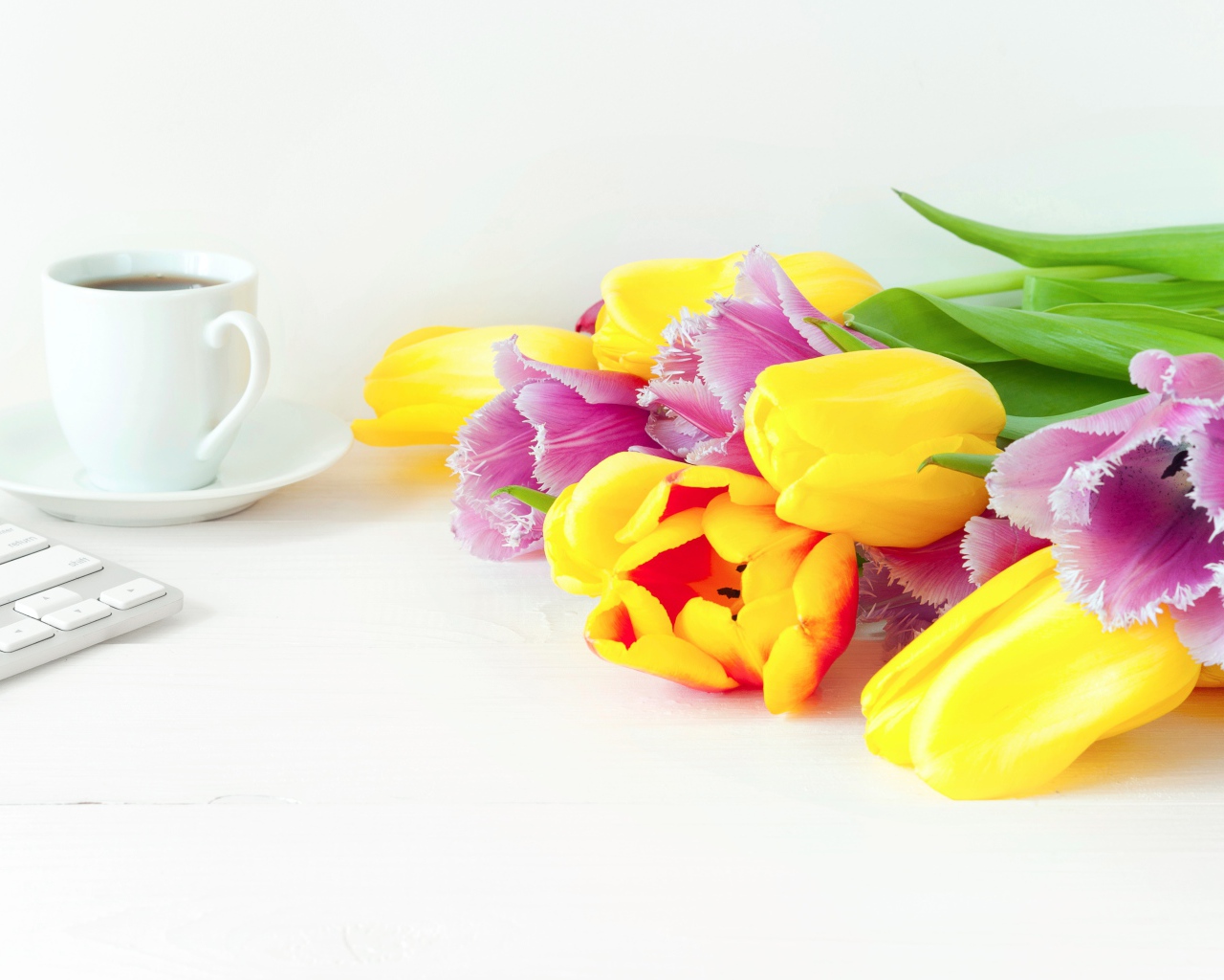 Желтые и розовые тюльпаны на столе с кофе