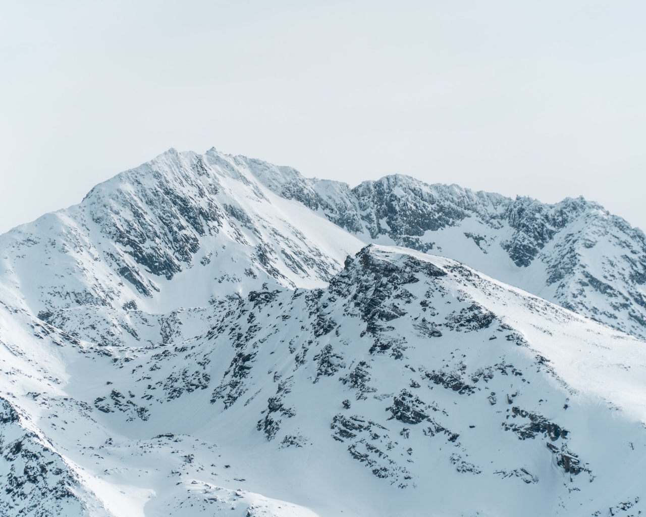 Заснеженная гора под серым небом 