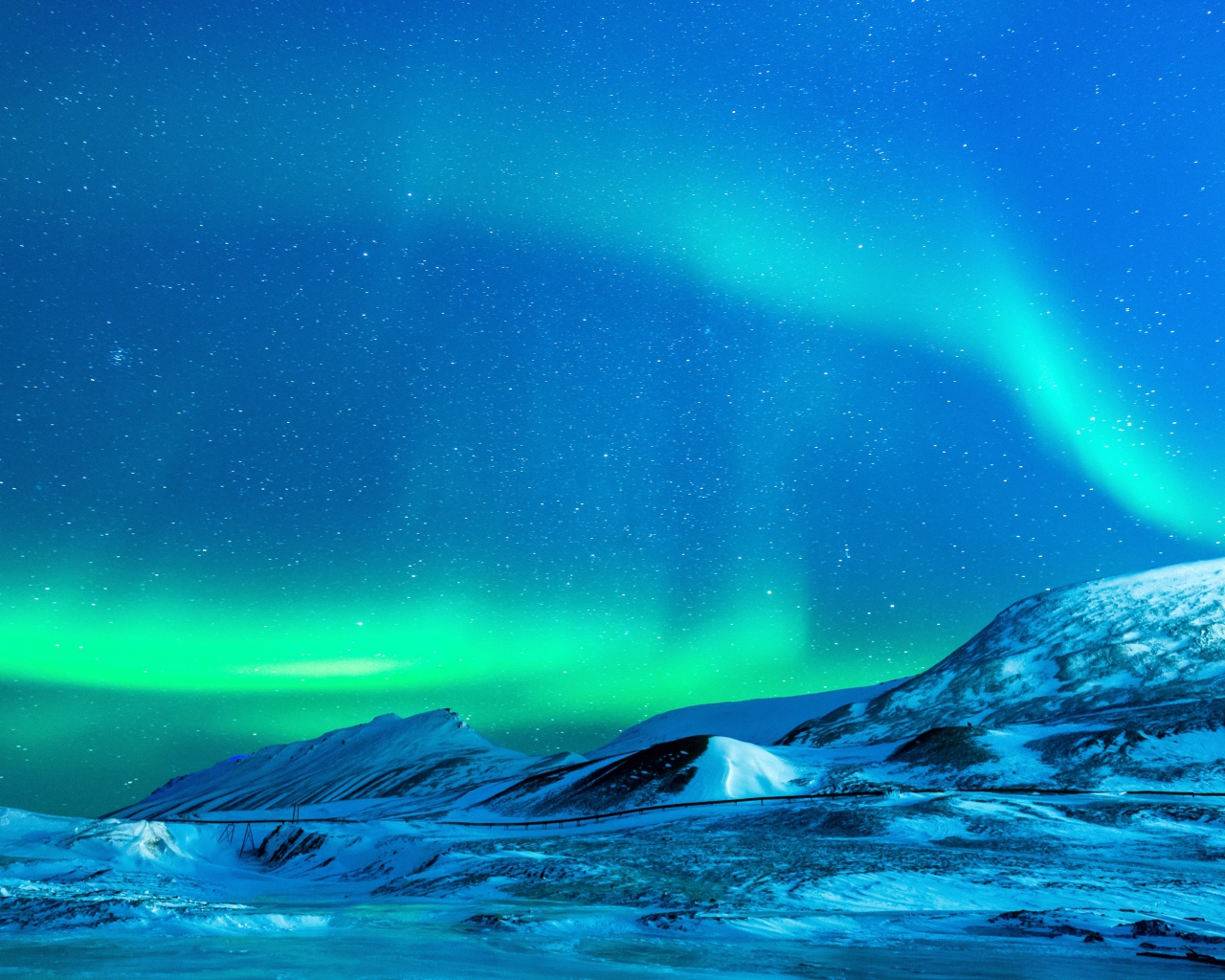 Небо с северным сиянием над заснеженными горами