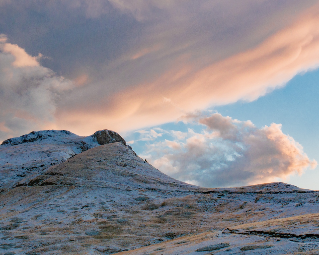 Красивые серые облака над заснеженной горой 