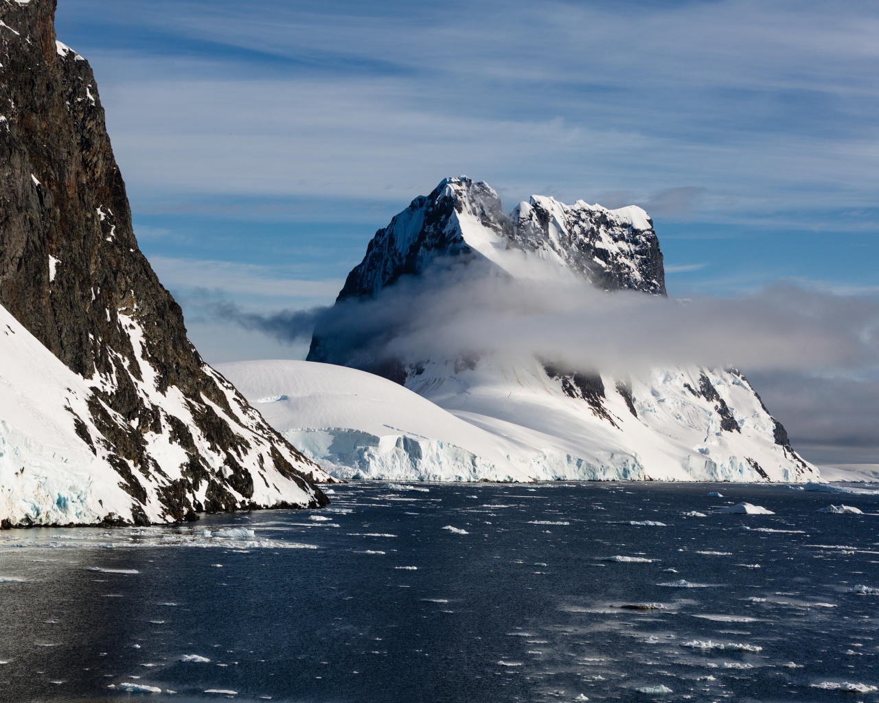Заснеженные горы у покрытого льдом океана 