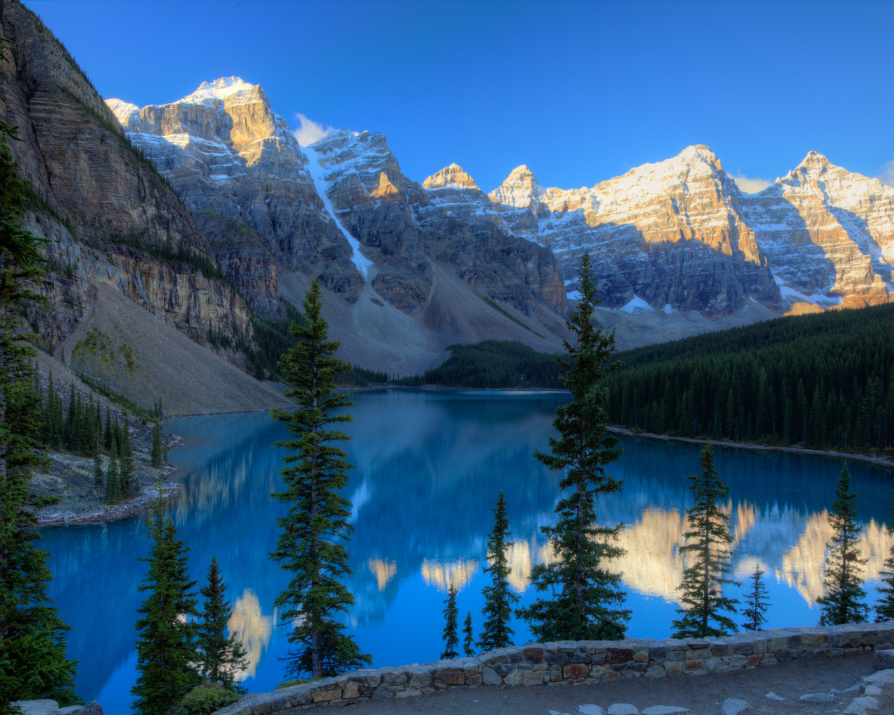 Каменные горы с заснеженными вершинами у озера 