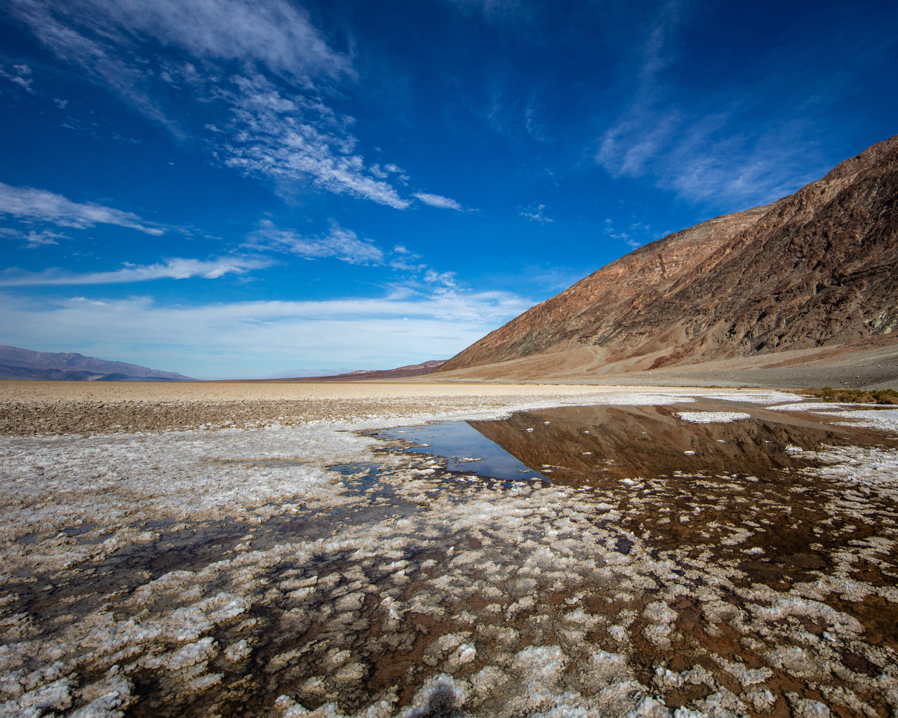 Соленая земля у горы под голубым небом