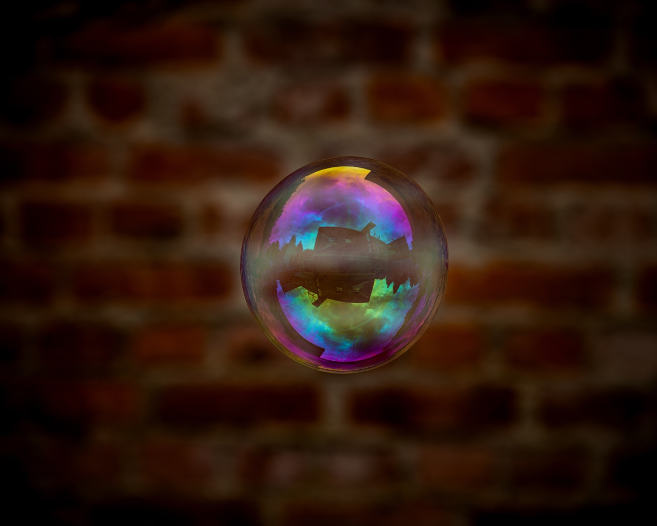 Мыльный пузырь в воздухе на фоне стены