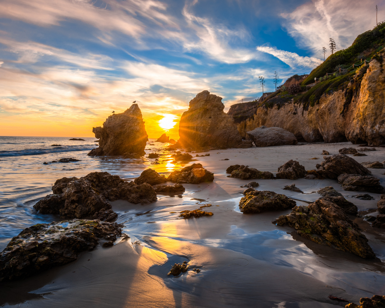 Яркий рассвет летнего солнца над скалами и океана