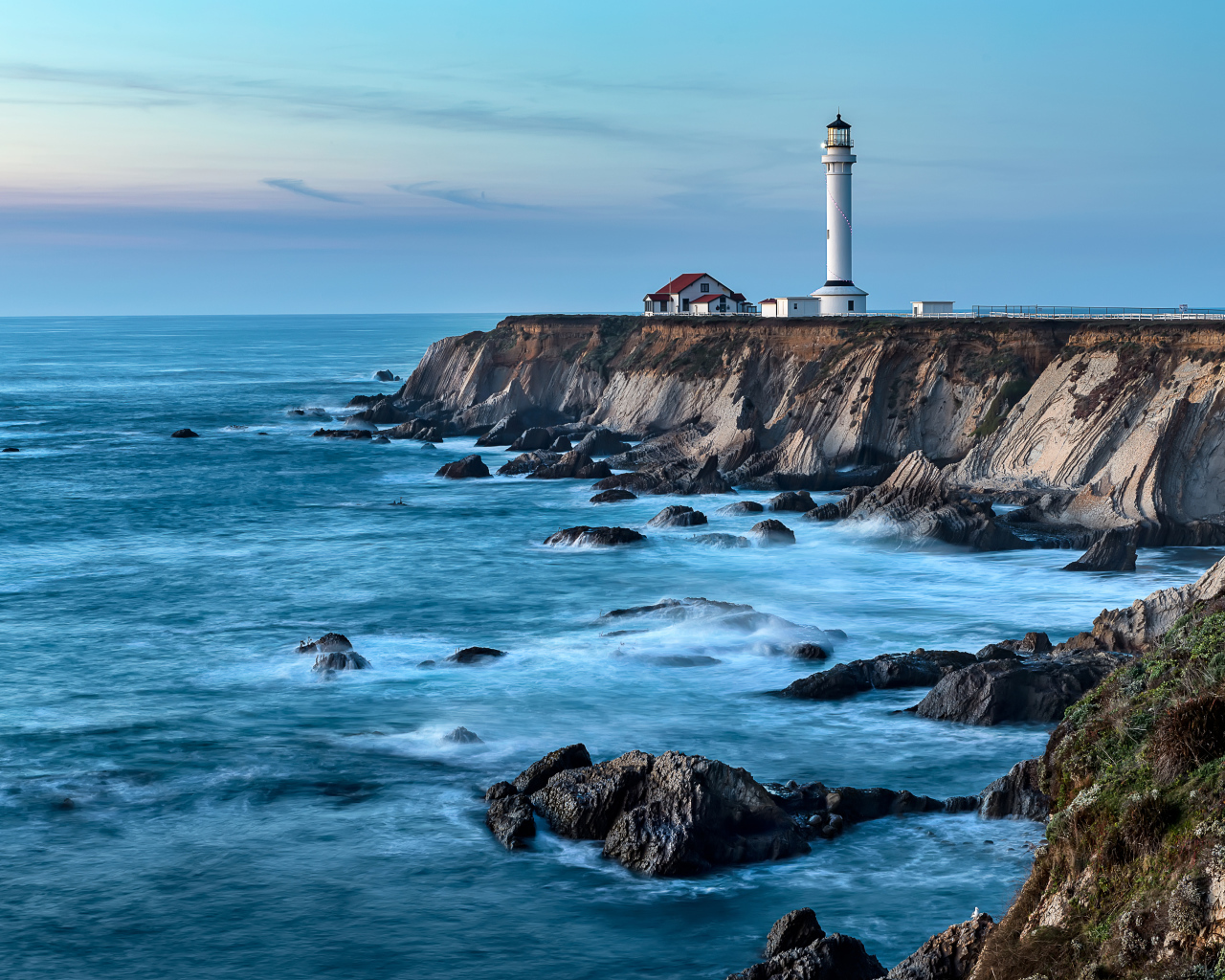 Маяк на берегу моря на краю утеса 