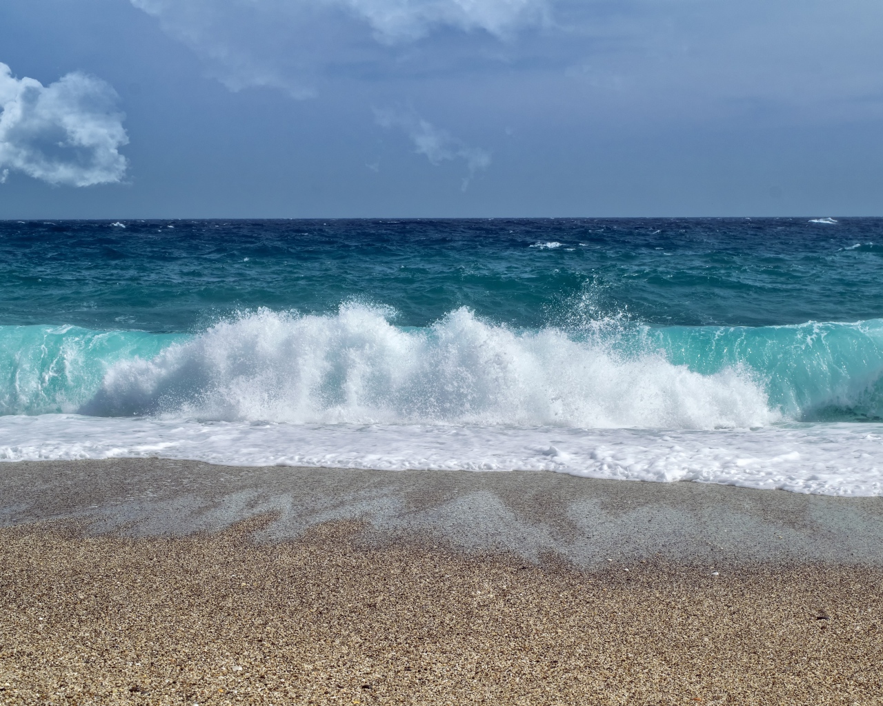 Голубые волны океана на мокром песке 