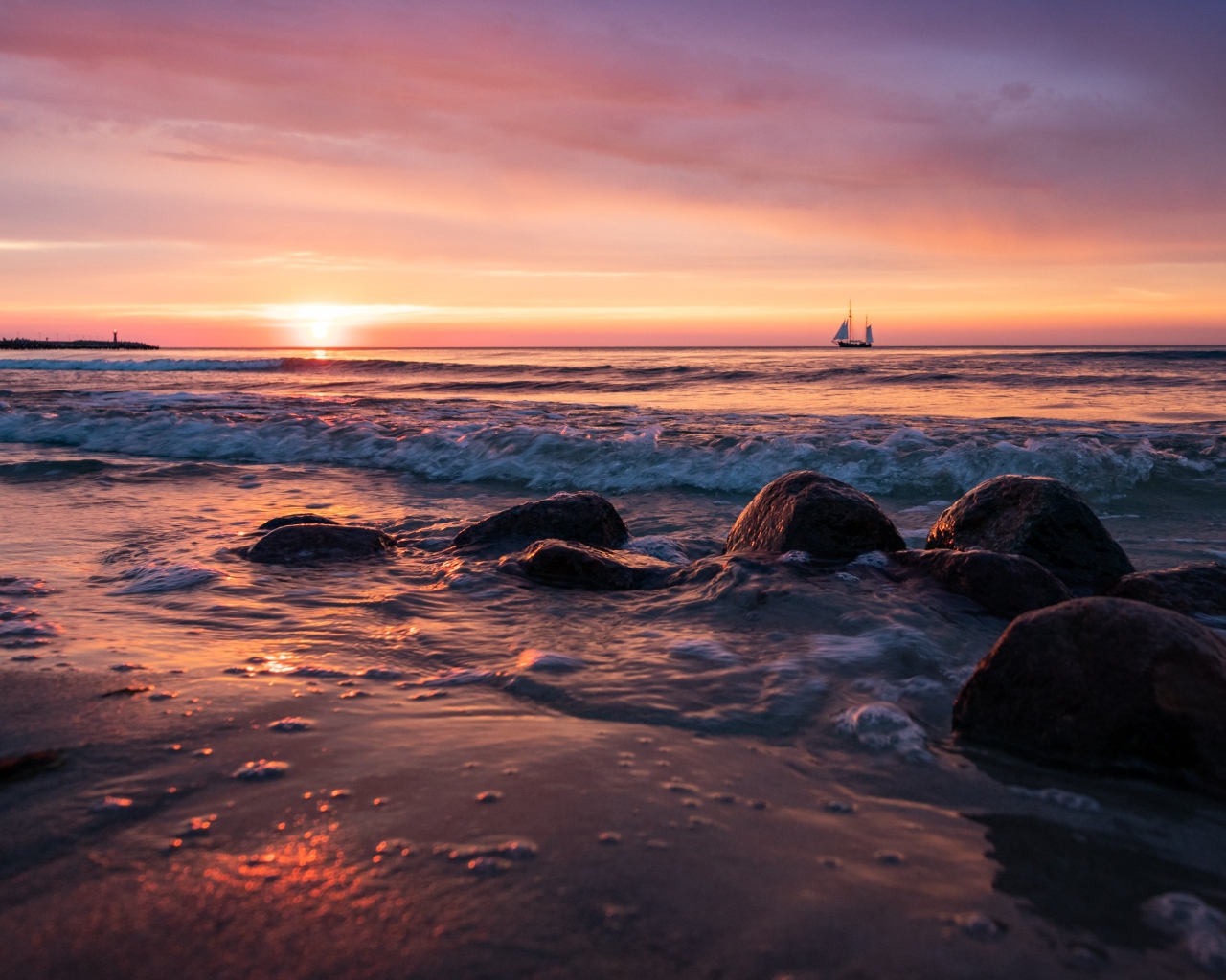 Валуны на берегу моря на мокром песке 