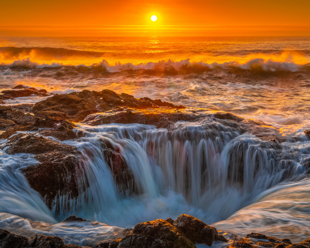 Вода океана стекает в дыру на закате солнца