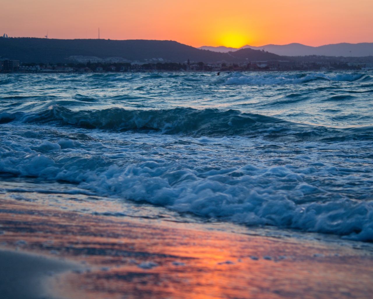 Бушующие волны на берегу моря на закате 