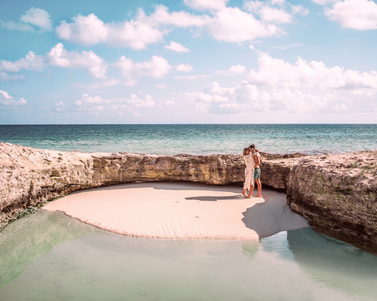 Каменное ограждение на морском пляже летом 