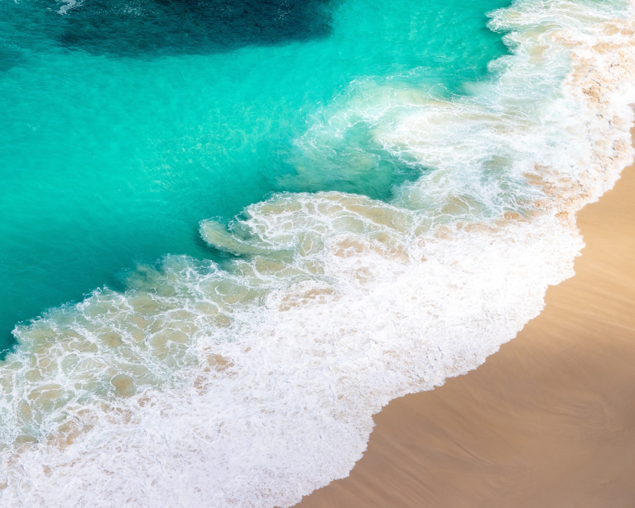 Вид сверху на белые волны прибоя 