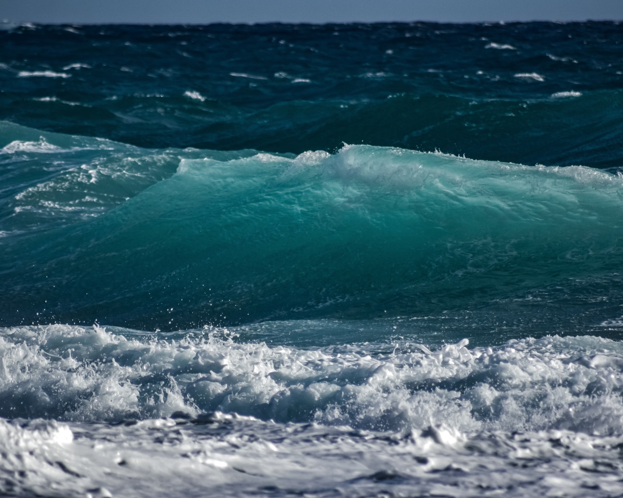 Волны с белой пеной поднимаются в море