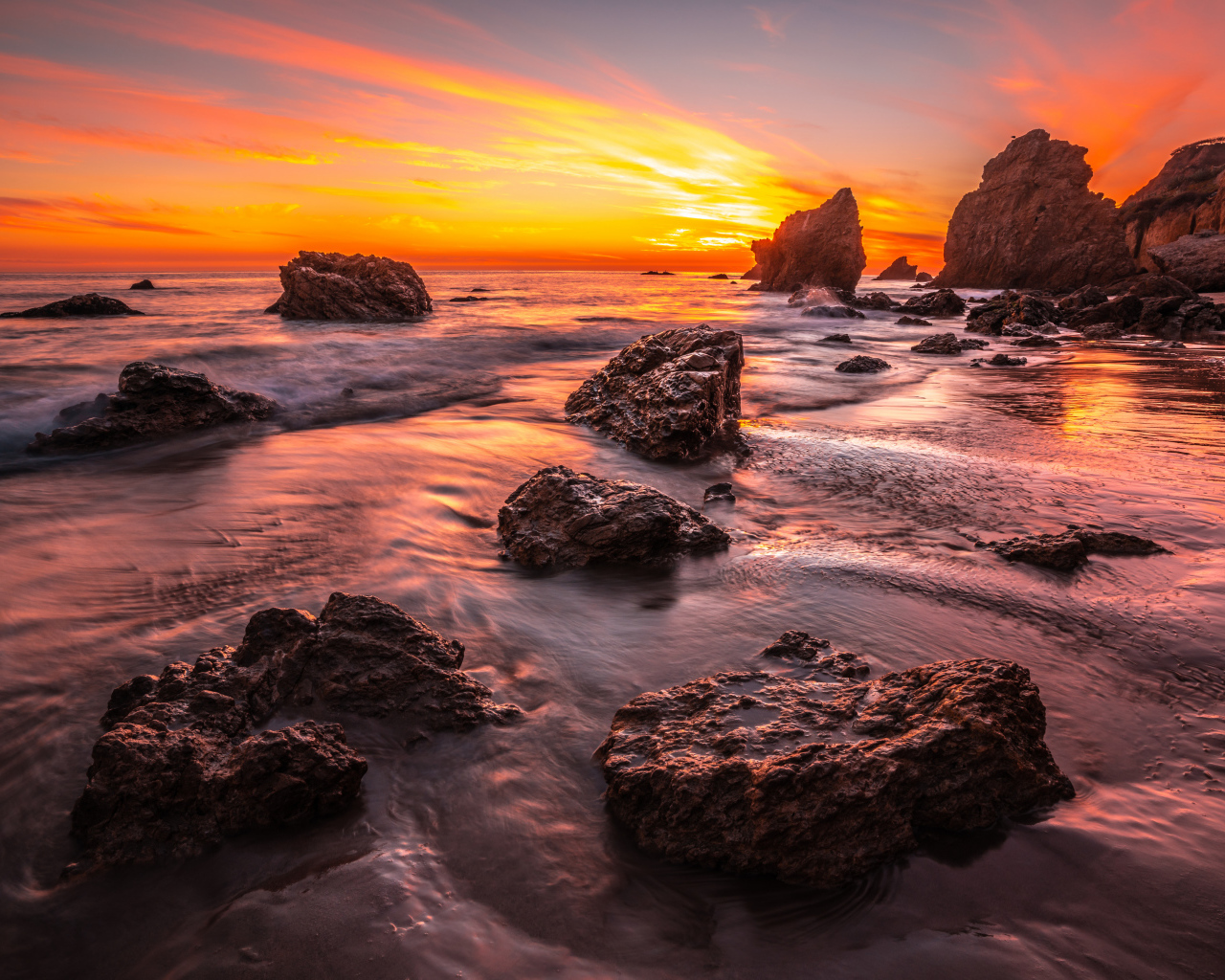 Красивый закат солнца на берегу моря с камнями 