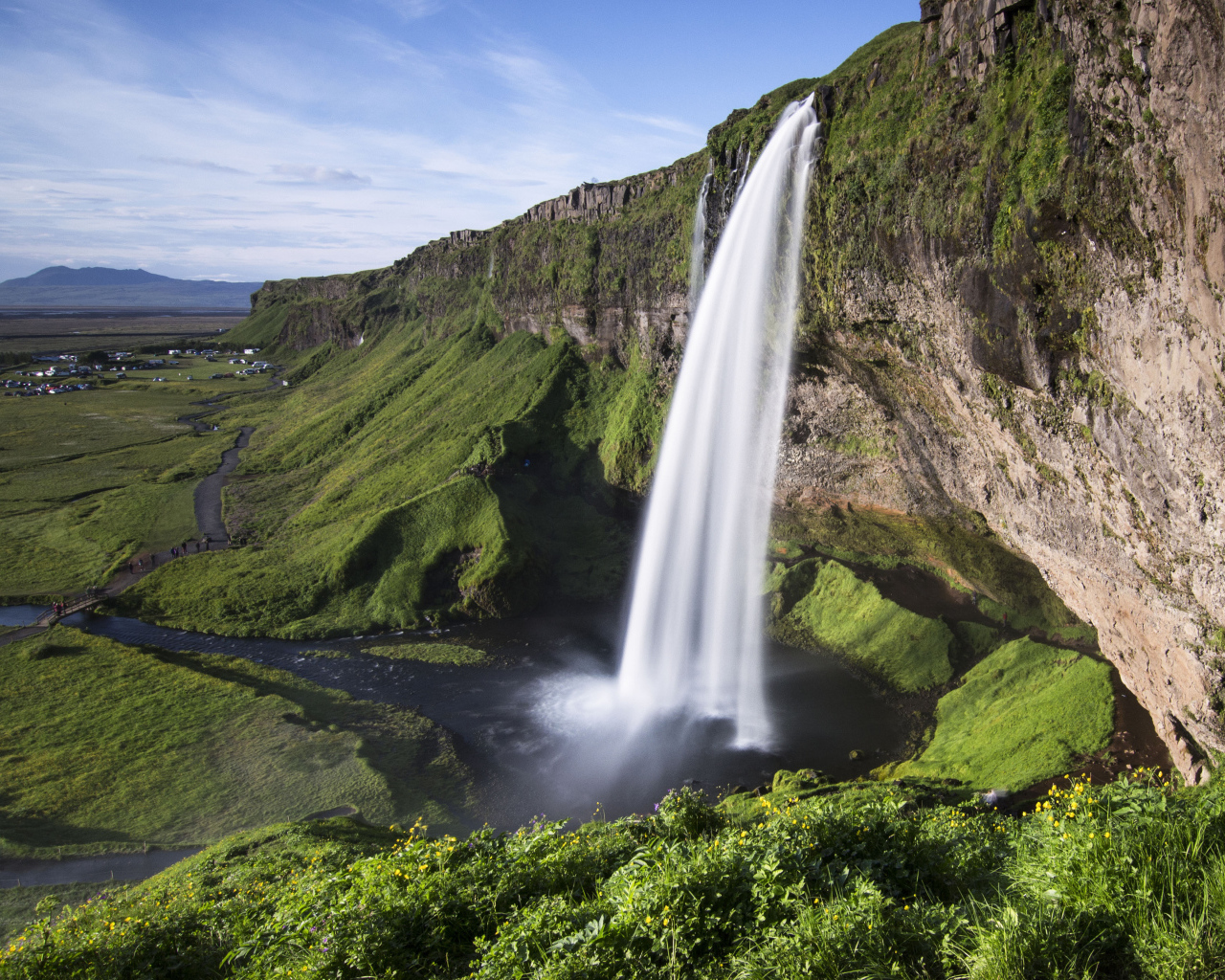 Быстрый водопад Сельяландсфосс стекает со скалы, Исландия