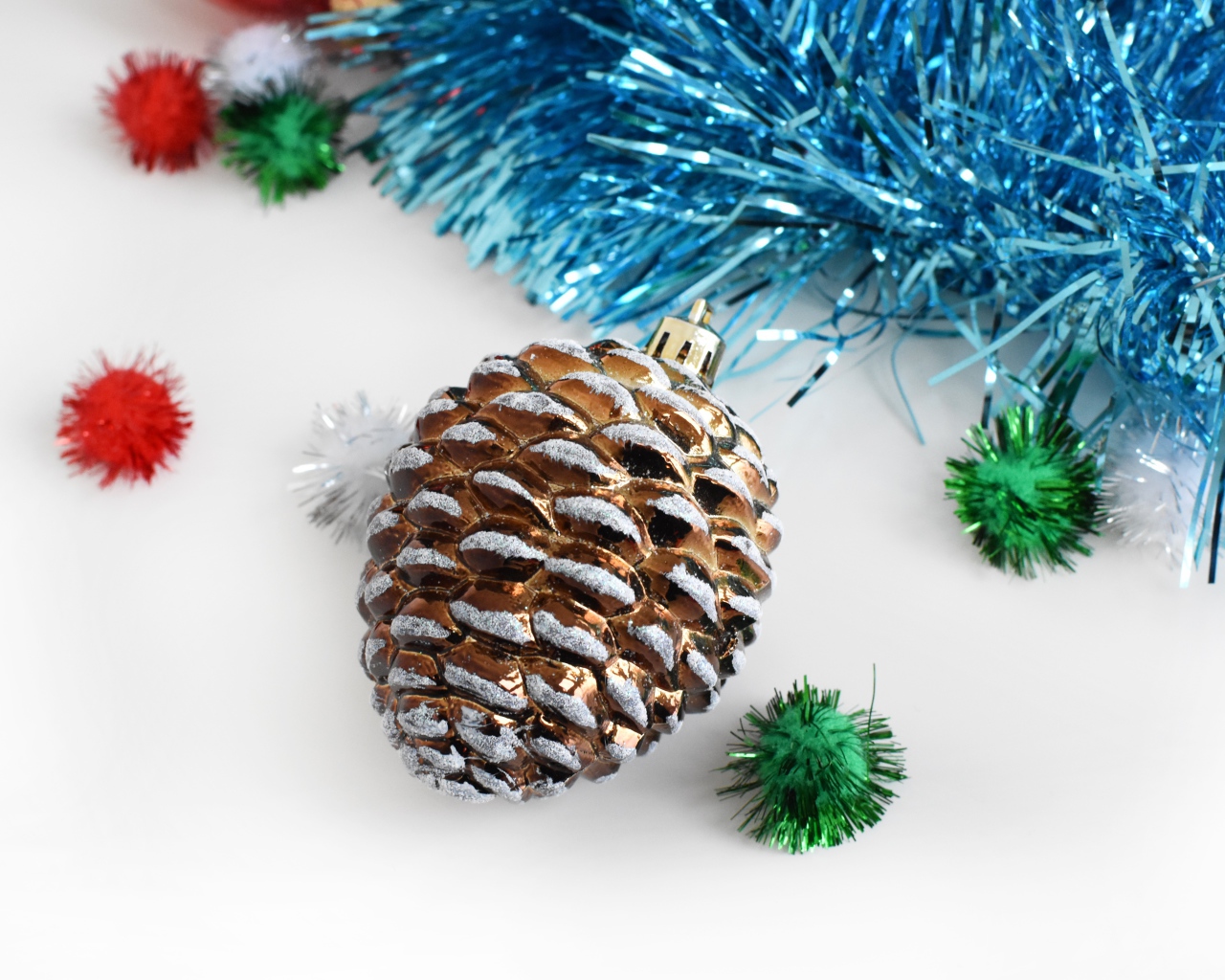 Елочная игрушка шишка с мишурой на белом фоне 