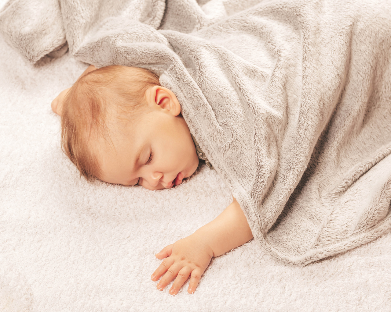 Грудной спящий ребенок под одеялом 