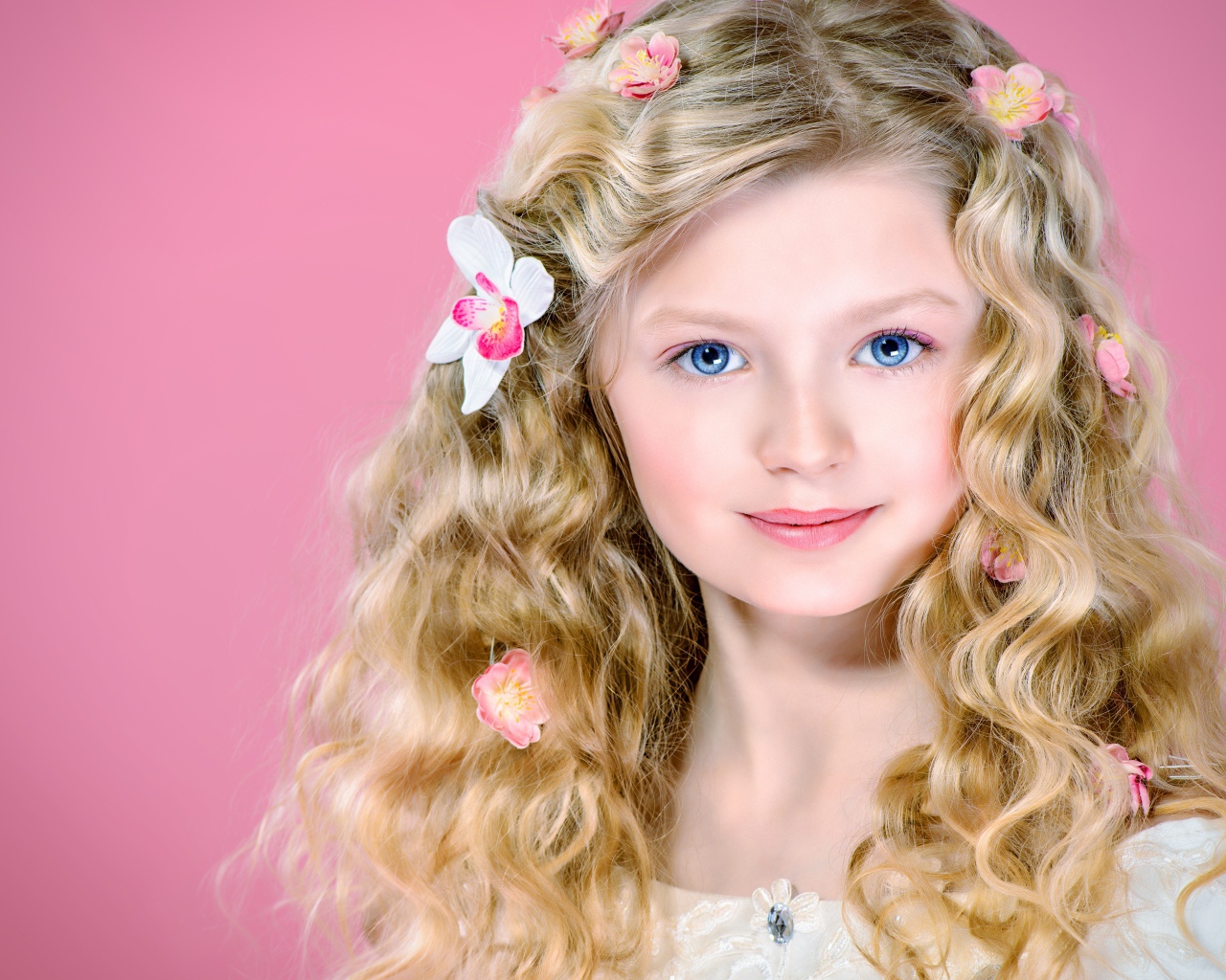 Красивая голубоглазая девочка блондинка на розовом фоне