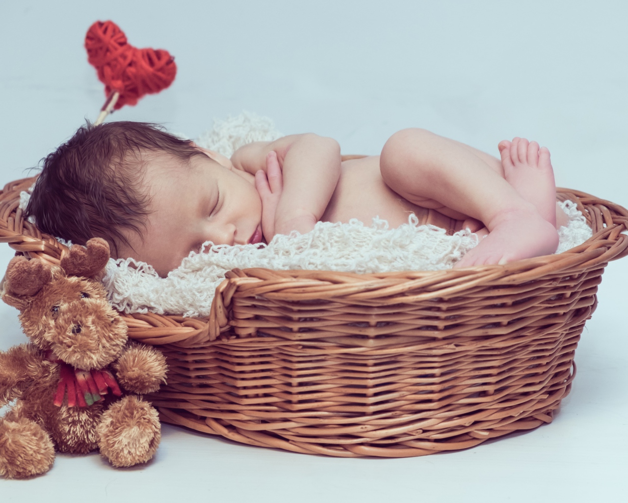 Красивый маленький грудной ребенок спит в корзине с игрушкой 