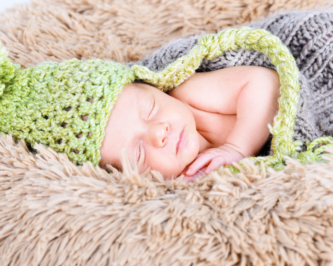 Красивый спящий грудной ребенок в вязаном костюме 