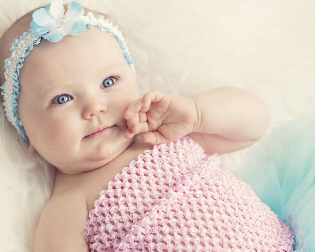 Голубоглазая маленькая девочка с повязкой на голове 