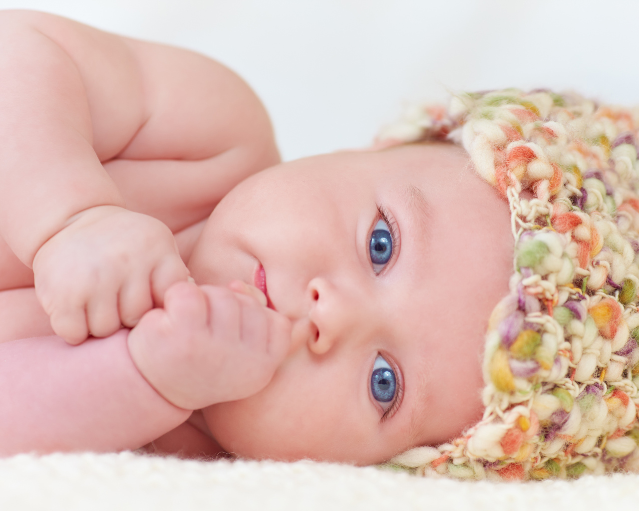 Голубоглазый грудной ребенок в шапке 