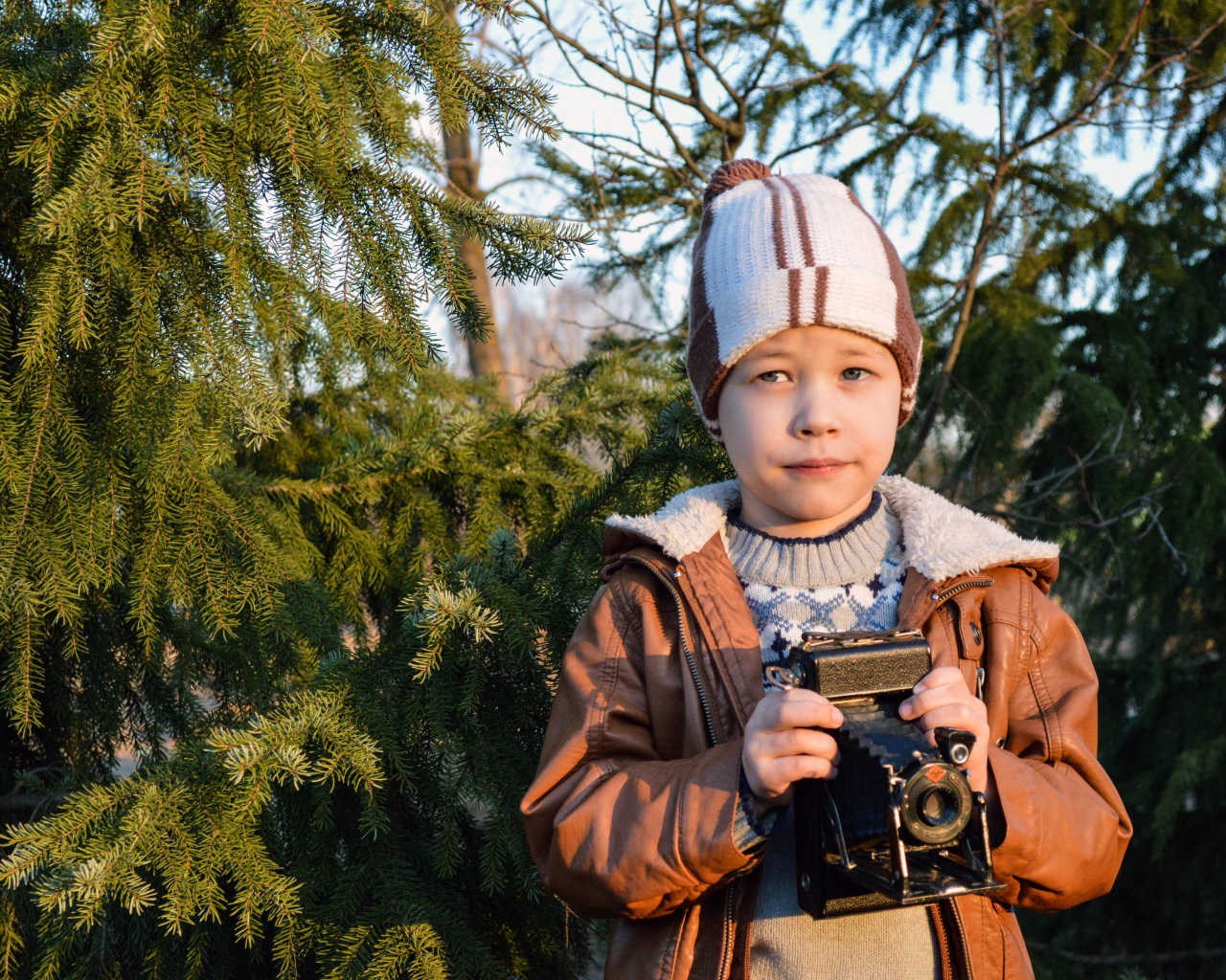 Мальчик с фотоаппаратом у ели