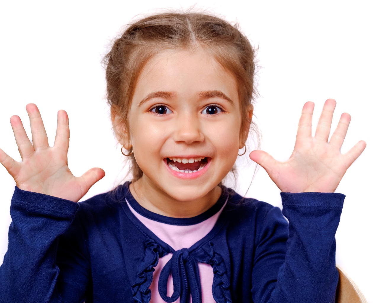 Веселая маленькая девочка с поднятыми руками