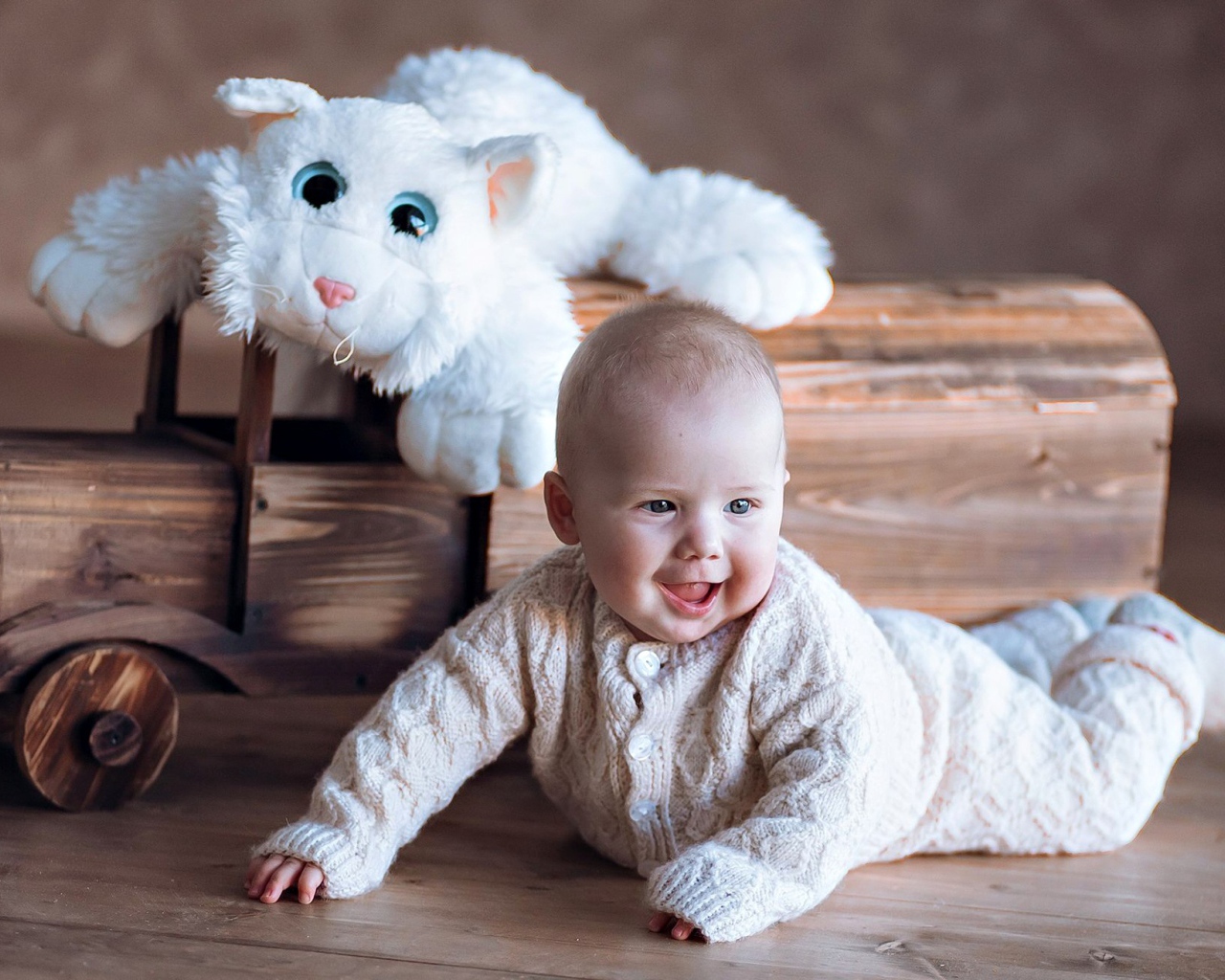 Веселый грудной ребенок с игрушечной машинкой 