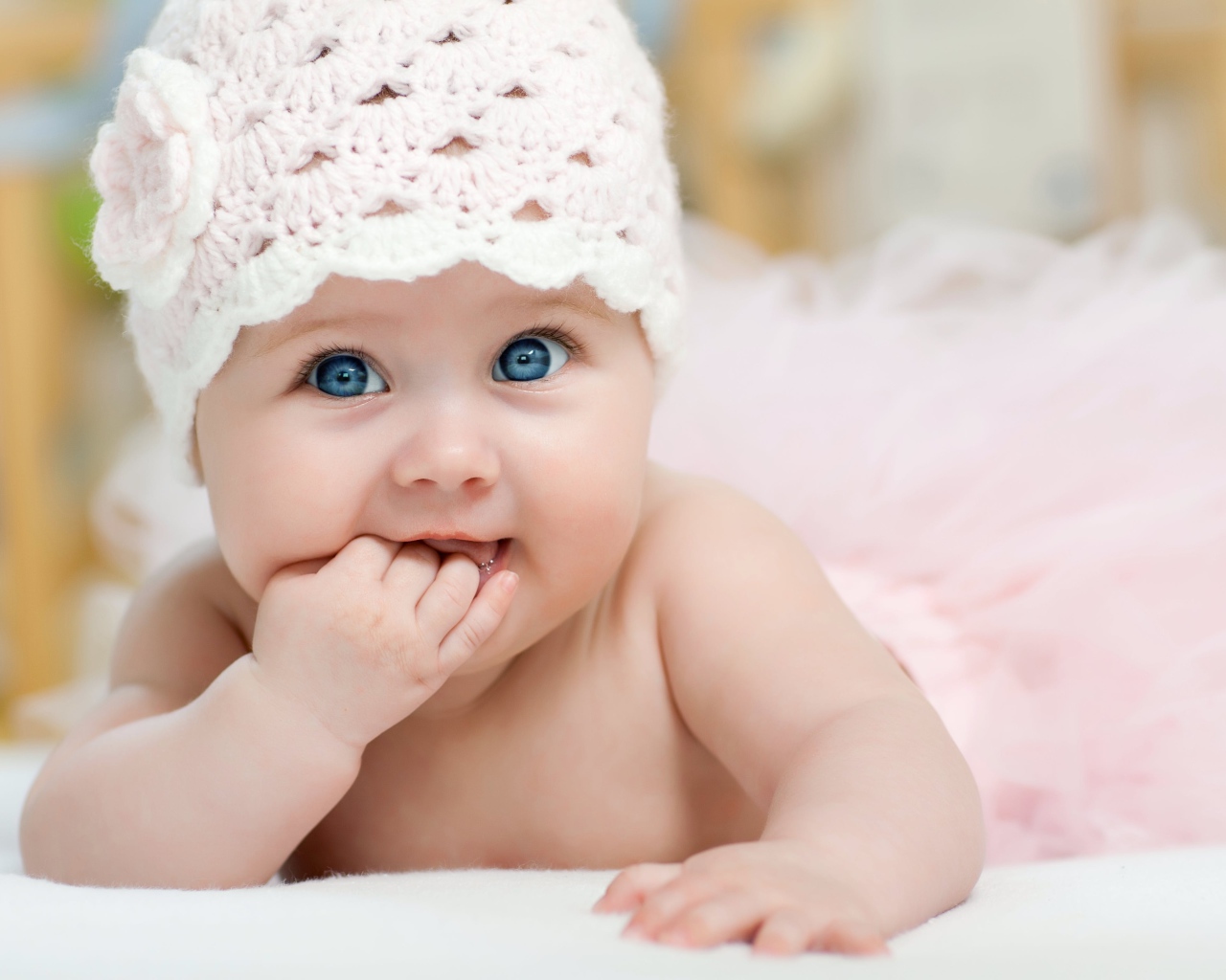 Милая голубоглазая малышка в розовой шапке 