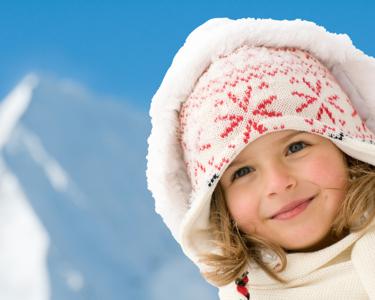 Милая маленькая девочка в шапке на фоне неба
