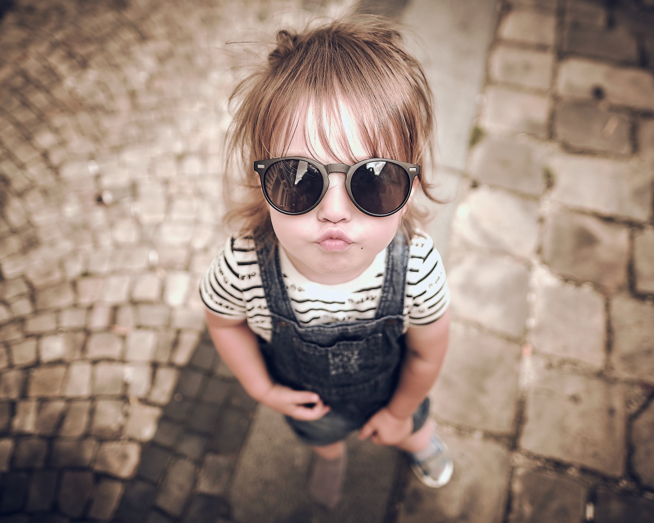 Модная маленькая девочка в черных очках