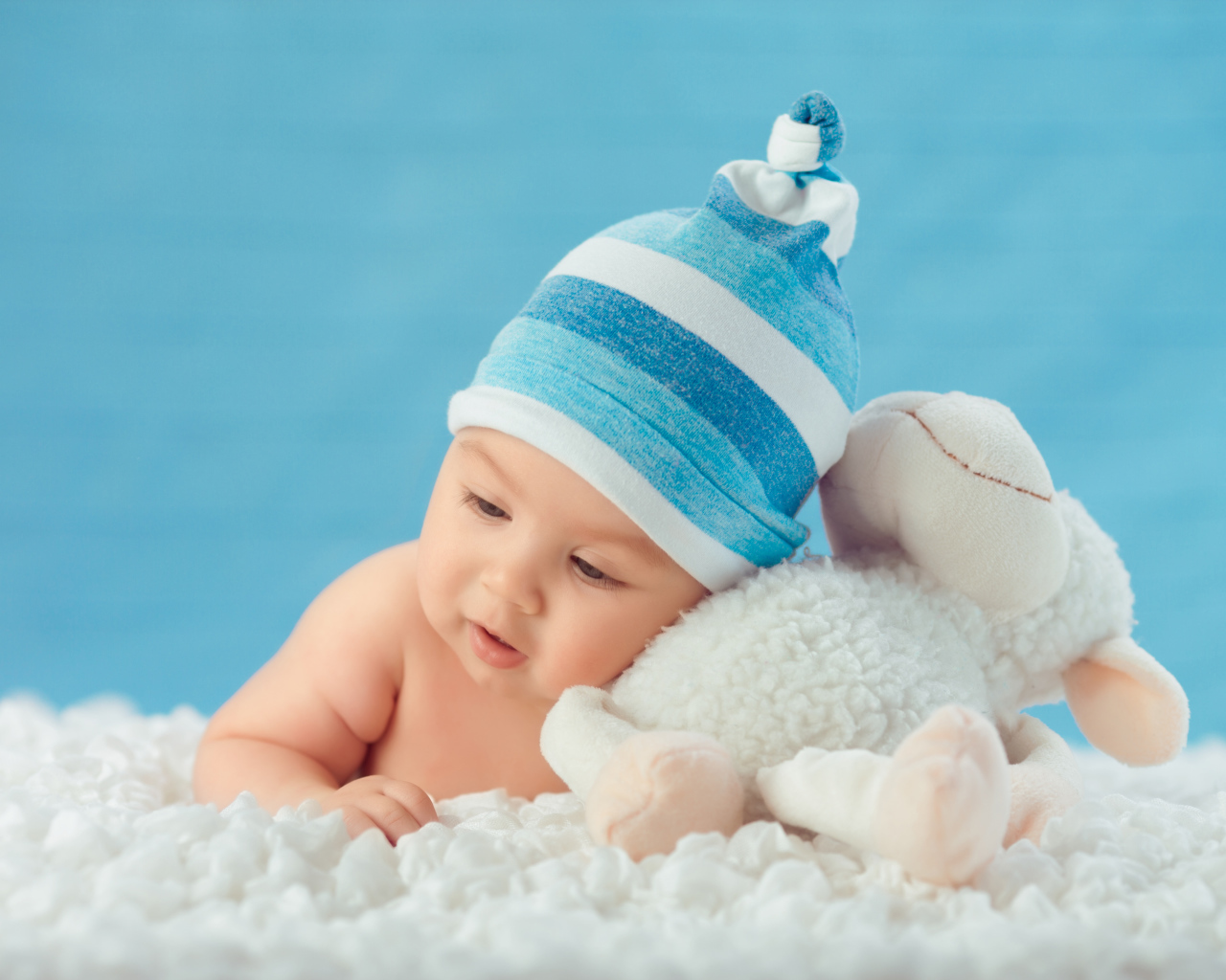 Забавный малыш с игрушкой на голубом фоне